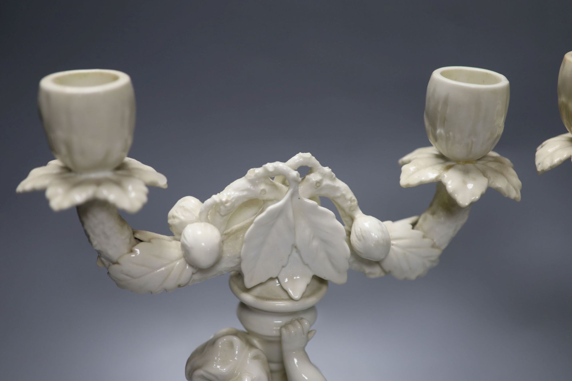 A pair of English bone china cherub candelabra, possibly Moore Bros., height 26cm